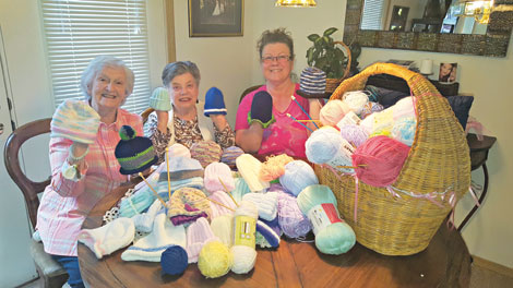 Pat Notson, Edith Mahn and Destinee Hewson Stavano (from left) knit caps that are donated for newborn children at St. Francis Hospital in Federal Way.