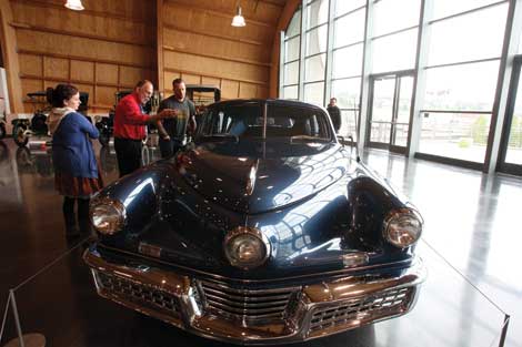 Classic automobiles at LeMay-America's Car Museum include the 1948 Tucker that tour guide Bill Simons (in red shirt) talks about with admirers. (Jim Bryant/Senior Scene)