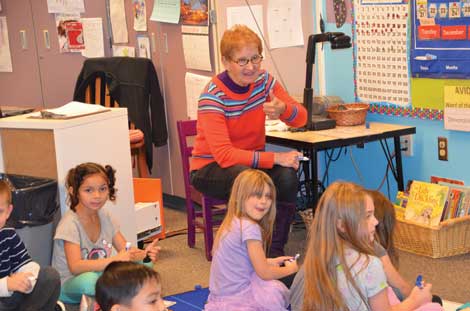 Marcia Madsen gives her kindergarten students at Woodland Elementary School a thumbs-up during a reading and writing assignment. Madsen, a teacher for more than 20 years, is 70 but has no plans for retiring. (Joan Cronk/Senior Scene) 